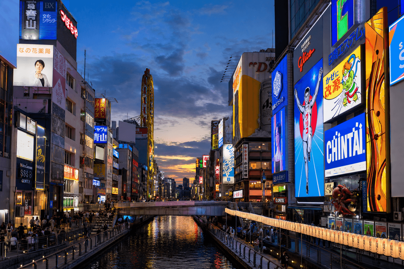 Pedestrian shopping street crowded with people at night, surrounded by glowing shop signs